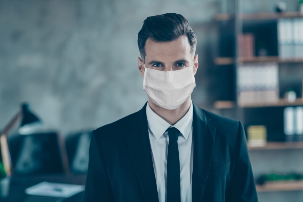 Man in a suit with a mask on